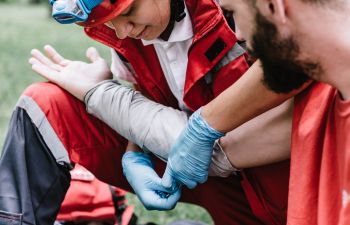 A paramedic giving first aid to a man with burn hand injury.