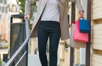 Woman coming out of store with shopping bags losing balance on a slippery surface.